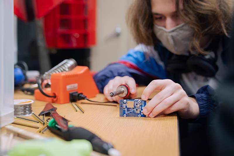 Space City UAV members soldering components for the drone.