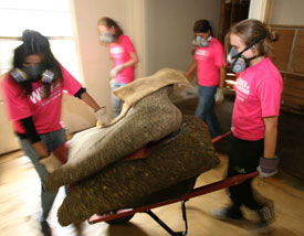 With the help of other UH volunteers, Kara Smits, a junior majoring in mechanical engineering, hauls a load of soggy carpet padding from Douglas' home. Photo by Thomas Shea.