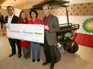 BP's Gerald Balboa, Elizabeth Nguyen (2006 BSChE) and Gabriel Cuadra (1988 BSChE) present UH President Renu Khator with a $300,000 check and an environmentally friendly solar utility vehicle. Photo by Tom Shea.