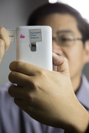 Electrical and computer engineering Associate Professor Wei-Chuan Shih examines things on his smartphone turned microscope