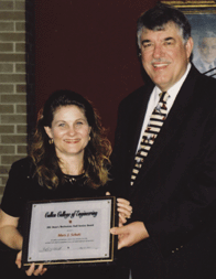 Dean Flumerfelt presents the Dean's Meritorious Staff Award to Mary Schulz.