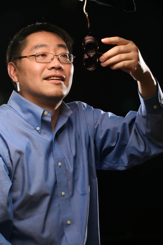 Electrical and Computer Engineering Professor Ji Chen with an electromagnetic coil designed for for brain stimulation.