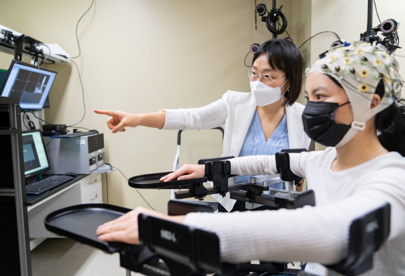 Jinsook Roh, assistant professor of Biomedical Engineering at the Cullen College of Engineering, works with a student volunteer. The machine can be used to form a baseline following a stroke, and to monitor recovery progress.