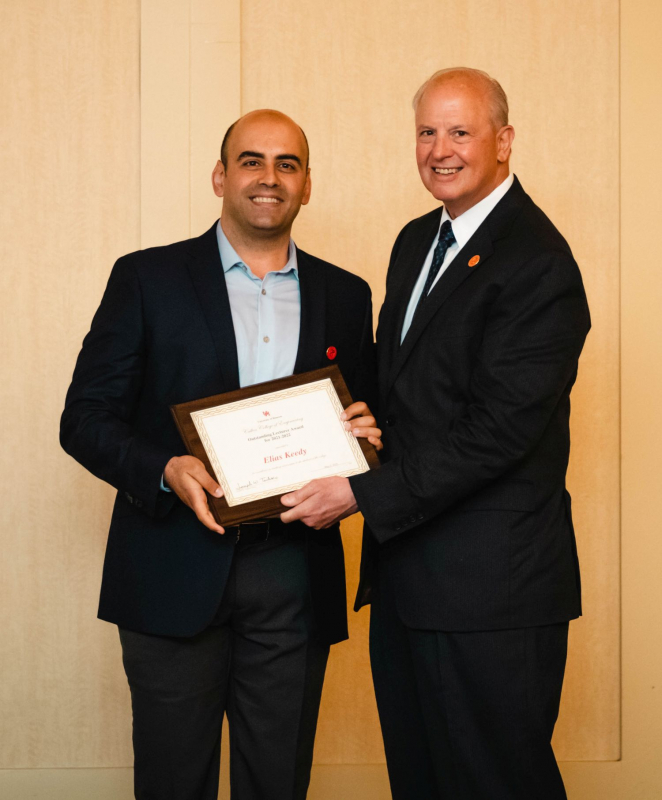 Elias Keedy accepts a Teaching Excellence Award at the 2022 luncheon from Dean Joseph Tedesco. 