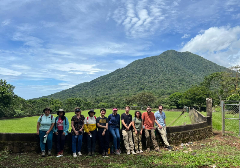 Posing for a group photo with a scenic backdrop. 