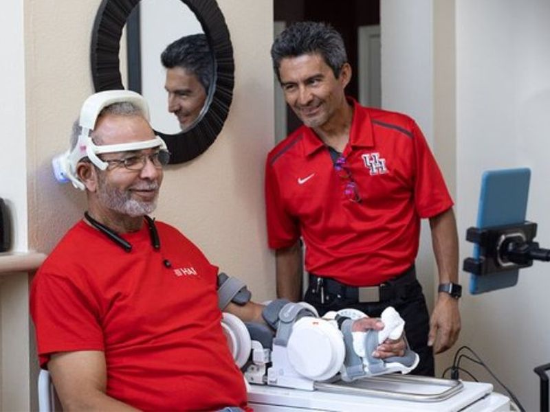 Passionate about brain waves, Jose Luis Contreras-Vidal, Hugh Roy and Lillie Cranz Cullen Distinguished Professor of electrical and computer engineering, is an international pioneer in noninvasive brain-machine interfaces and robotic device inventions. Here he is working with a patient testing the at-home equipment. 