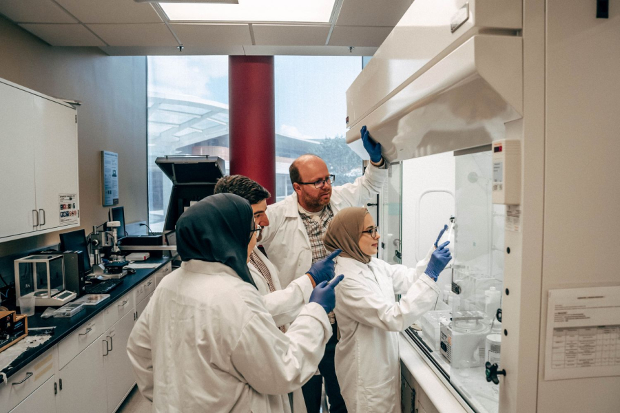 Konrad Krakowiak [background] and his research group demonstrate a machine in the lab.