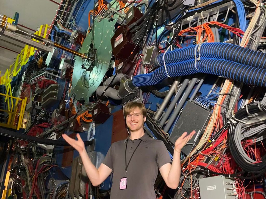 Physics Ph.D. student Caleb Broodo studies the trajectories of particles emitted from two billion collisions of atomic nuclei at Brookhaven National Laboratory’s Relativistic Heavy-Ion Collider. As a member of the STAR collaboration, he uses a bus-sized detector to examine thousands of particles produced inside the collisions.