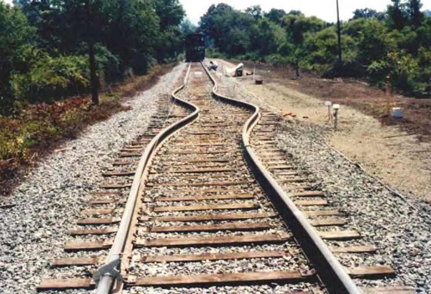 When railroads experience significant enough stresses, they can become detached from their fastening systems. This can result in lateral deformations such as buckling – large S-shaped curves or kinks in what should be otherwise neatly-aligned rails. This image, courtesy of the USDOT, depicts an example of buckling.