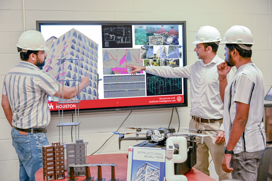 Hoskere (center) discusses the applications of AI for design and evaluation of structures with PhD students Taseer Ali (left) and Deepank Kumar Singh (right).