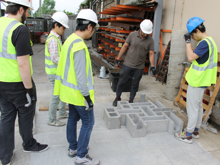 Waleed Khan [dark green shirt] leads a group of students at Masonry Day. 