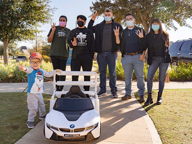 Zach Walther (3) gives a thumbs up to his new ride, presented by BMES students (Left-Right) Jasmine Dhaliwal, Martin Reyes, Collin Rhodes, Rogelio Castilla and Hannamarie Ecobiza.