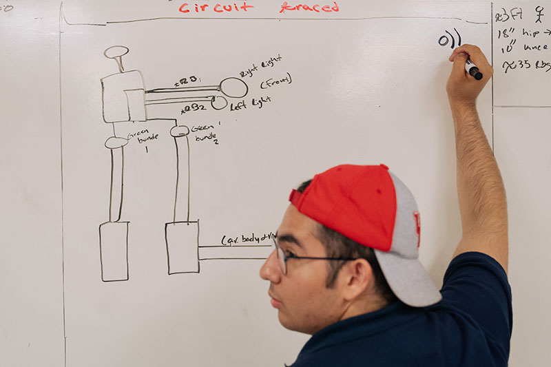 Rogelio Castilla maps out circuits on the car to rewire later in the build process.