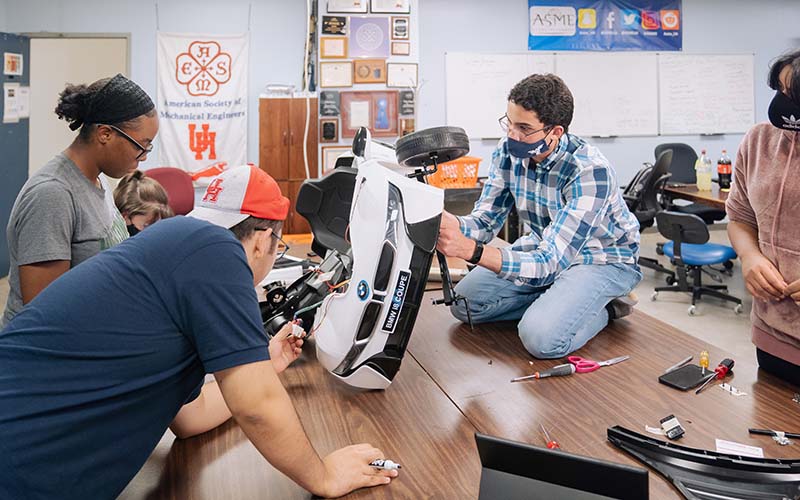 Jasmine Dhaliwal deconstructs the steering wheel. The group moved a pedal button to the steering wheel so the car could be operated without feet.