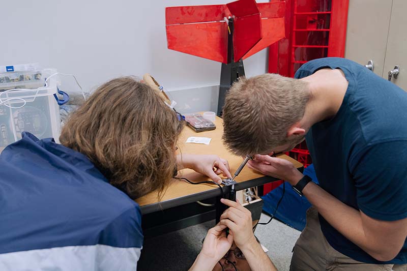 Space City UAV members soldering components for the drone.
