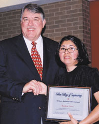 Dean Flumerfelt presents the Dean's Meritorious Staff Service Award to Barbara Torres.