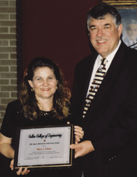 Dean Flumerfelt presents the Dean's Meritorious Staff Award to Mary Schulz.