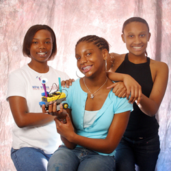 From left, Dezranique Stansberry, Chase Williams and Arielle Auguillard hold up the robot they built during UH’s GRADE camp. Photo by Jeff Shaw