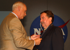 William F. Readdy pins Stanley Kleis with the Public Service Medal. Photo by Jeff Shaw.