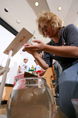 Coleman Rink, a freshman biomedical engineering major, rigs his team's contraption for a class demonstration. The machine was designed to feed a goldfish remotely. Photo by Thomas Shea.