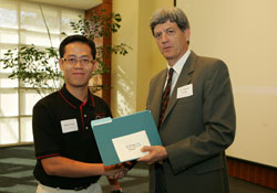Electrical engineering major Minh Tran receives an award from Stuart Long, interim dean for The Honors College, for his poster presentation at Undergraduate Research Day.