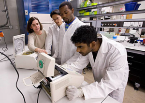 Undergraduate biomedical student Shaun Khan studies a BioRad Thermocycler located in the new Biomedical Engineering Bioanalytics Undergraduate Laboratory. Also pictured are Laura Gutiérrez, Ph.D., manager of the lab, and students James Liu and Valor Thomas. Photo by Tom Shea.