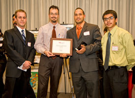 FMC Technologies representatives Preston Bruce and Chris Egan present $1,000 to Andres Michel and Fernando Alquicira of the UH Society of Mexican American Engineers and Scientists (MAES) for winning first place in the EAA Engineering Community Outreach Competition. Photo by Jeff Fantich