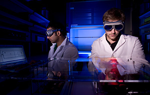 Undergraduate biomedical engineering students Arjun Vasan (left) and Basilios Sideris demonstrate how to operate the homemade lab instrument they developed over the course of the last year. Photo by Thomas Shea.