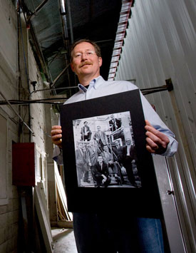 Scott Prengle holds an old photograph showing his father, H. William Prengle, and other chemical engineering faculty posing for a picture in Y Building during a visit to the structure recently. Photo by Thomas Shea.