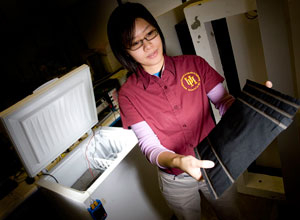 Mechanical engineering graduate student Christiana Chang holds a sheet of carbon nanofiber paper she is embedding in concrete in an effort to create self-heating roads. Photo by Thomas Shea.