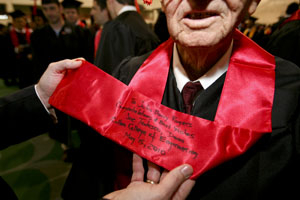 Toby Hooper, Rogers' grandson, reads the sash presented to his granfather by the Cullen College dean. It reads, "To John Berry Rogers, Congratulations and Best Wishes, Joe Tedesco, Dean Cullen College of Engineering, May 15, 2010." Photo by Thomas Shea.
