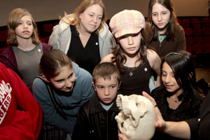 Students with The Friends School get an up close look at the replica skull of Thomas Smith. Photo by Thomas Shea.