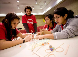 SWE member Juan Romero, a junior civil engineering major, helps area high school sophomores, Kelly Diaz, Edna Barrera and Rebeca Beltron construct a trebuchet during a recent outreach activity coordinated by the organization. Photo by Thomas Shea.