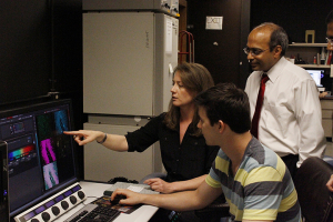 Dr. Badri Roysam and Dr. Leigh Leasure look over brain images with a graduate student researcher.