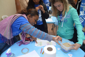 Fontaine Wilson assists a student on a project explaining the petroleum engineering discipline. (photo by Felipe Ponte)