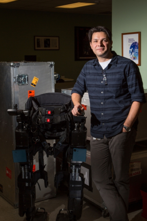 ECE researcher Atilla Kilicarslan standing next to "Neurorex"