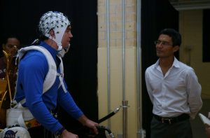 Jose Luis Contreras-Vidal (right) demonstrates his non-invasive brain-machine interface exoskeleton in 2013.