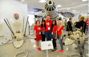 Jincy Philip, 2nd from left, and Anchal Bhaskar, 2nd from right, join international student participants in Lavochkin Aerospace Company museum, in front of moon orbital spacecraft