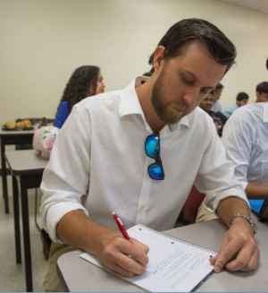 Waiting to present with his own team, UH engineering student James Schouten, takes notes on the performance of MIT's teams