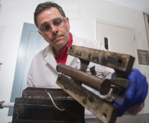 Konstantinos Kostarelos with his prototype that electro-kinetically removes sludge and gunk from crude oil pipes