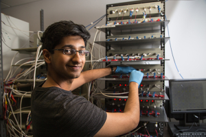 Top, Karun Kumar Rao works at a battery panel. Below, he holds a solid non-liquid battery with advisors (from left) Yan Yao and Lars Grabow