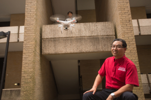 UH Professor Gino Lim with a student and a flying drone, a technology with lot of potential to provide cost-effective healthcare to rural Americans.