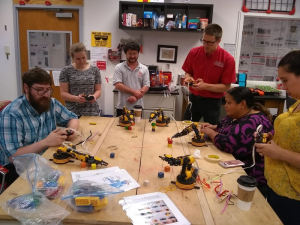 UH professor Aaron Becker (red shirt) and Julien Leclerc (next to him, gray UH shirt), a UH Cullen College research associate visit with Houston-area teachers and an undergraduate REU participant in the Robotic Swarm Control Laboratory.