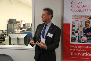 Robb Black, president & CEO of Omron Automation shares some insights with UH engineering students in front of the Omron Lab.