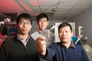 Dr. Yan Yao holds the solid-state battery, with Dr. Yanliang Liang next to him and Dr. Xiaowei Chi behind them at the UH Cullen College of Engineering.