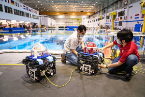 Associate Professor Aaron Becker and robotic swarm lab members Steban Soto and Javier Garcia conduct tests of a submersible ROV pairing at the Neutral Buoyancy Lab in August. 