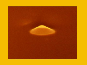 A laser-induced fountain, in yellow, is created by a laser beam shining on the surface of ferrofluid in the Bao lab. 
