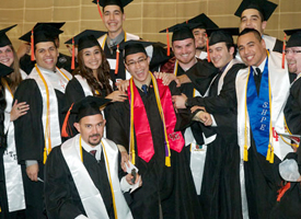 Mechanical engineering graduates huddle around David Levy, a 16-year double-graduate of mechanical engineering and mathematics at UH.