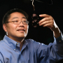 Electrical and Computer Engineering Professor Ji Chen with an electromagnetic coil designed for for brain stimulation.