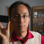 Associate Professor Jiming Bao and screen filled with graphene flakes suspended in solvent between two layers of glass. Bao discovered that a magnet rotates and aligns the flakes.
